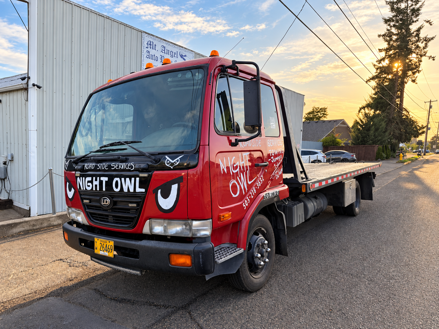 Night Owl Roadside Services flatbed tow truck outside Mt. Angel Auto Body & Paint for vehicle pickup and delivery