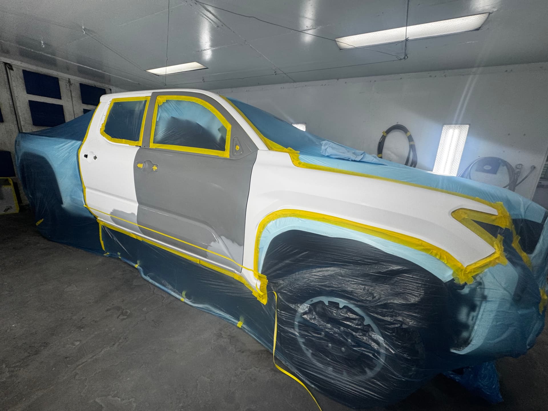 Pickup truck masked and primed in the spray booth at Mt. Angel Auto Body & Paint